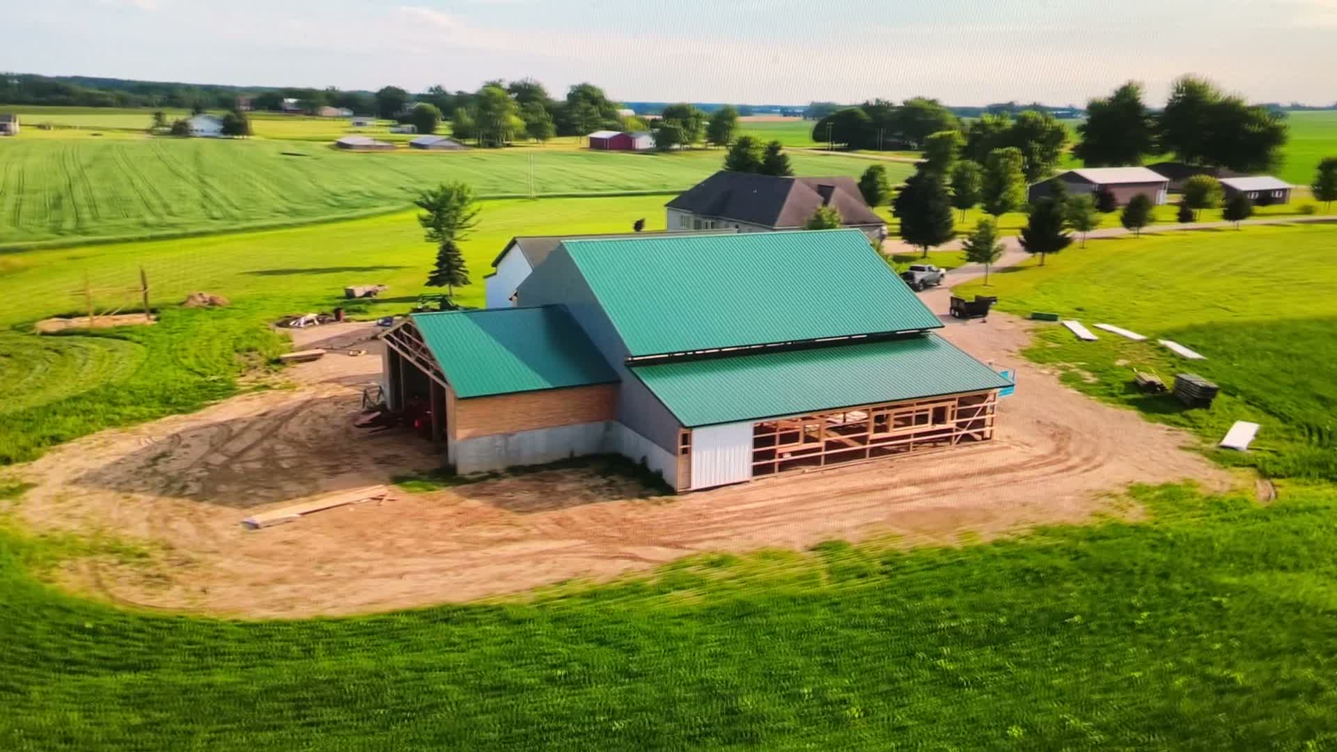 Aerial view of the Crimson Lane barn under construction, surrounded by Michigan pasture